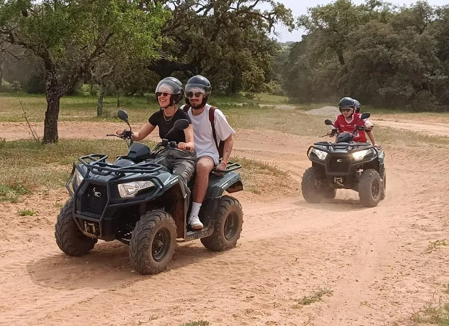 Rider with helmet and dust goggles at the controls of the quad